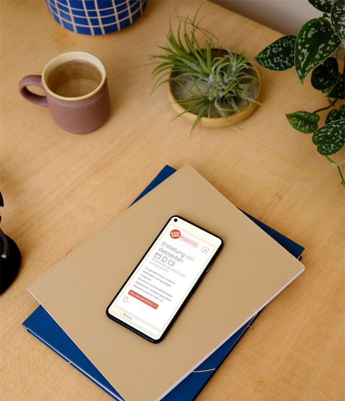Smartphone mit der Ansicht der schauWEB Homepage