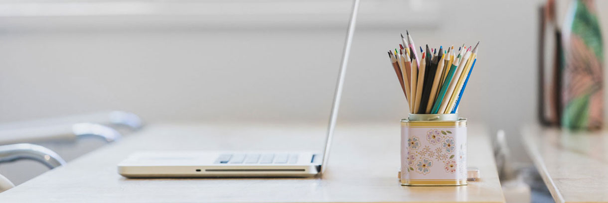 Schreibtisch mit Laptop und Buntstiften